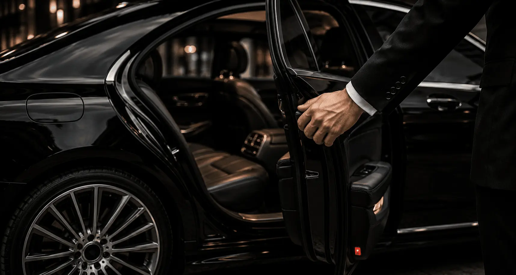 Professioneller Chauffeur öffnet die Tür einer schwarzen Luxuslimousine
